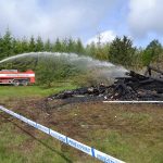 Räddningstjänsten i Skillingaryd tar inga risker långt efter branden bombas brandplatsen med vattenkanon.